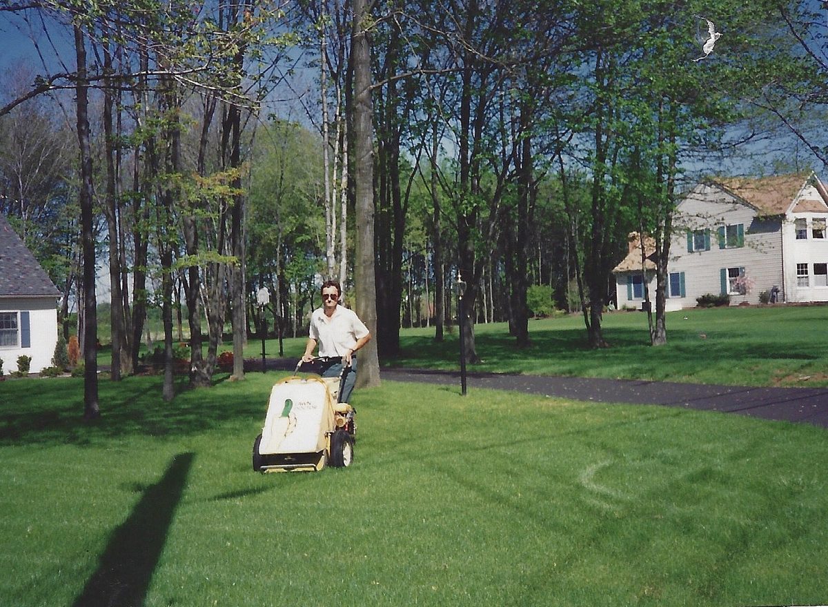 My dad mowing a customer's lawn in his early days in lawn care